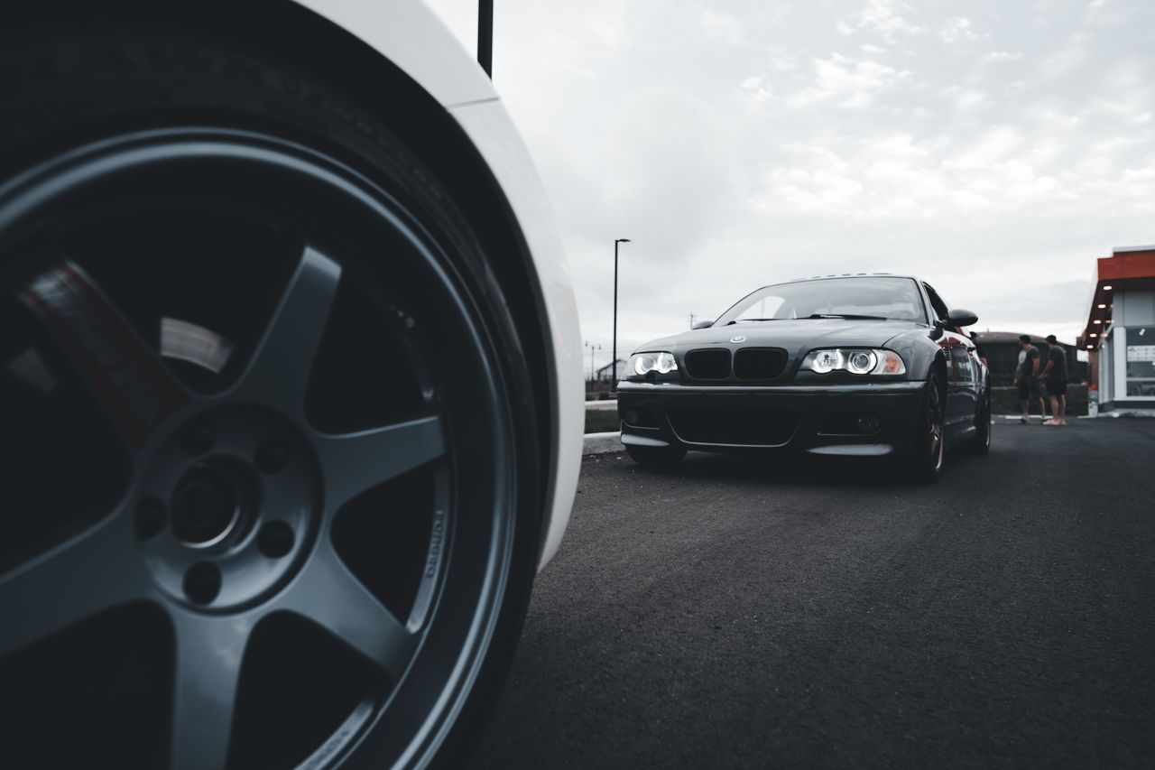 Home Dynamic shot of sleek sports cars on a wide asphalt road emphasizing power and speed.