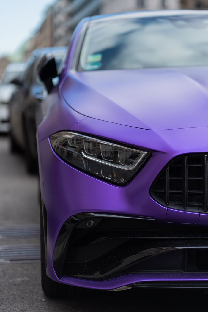 Close-up of a purple sports car headlight showcasing modern design.