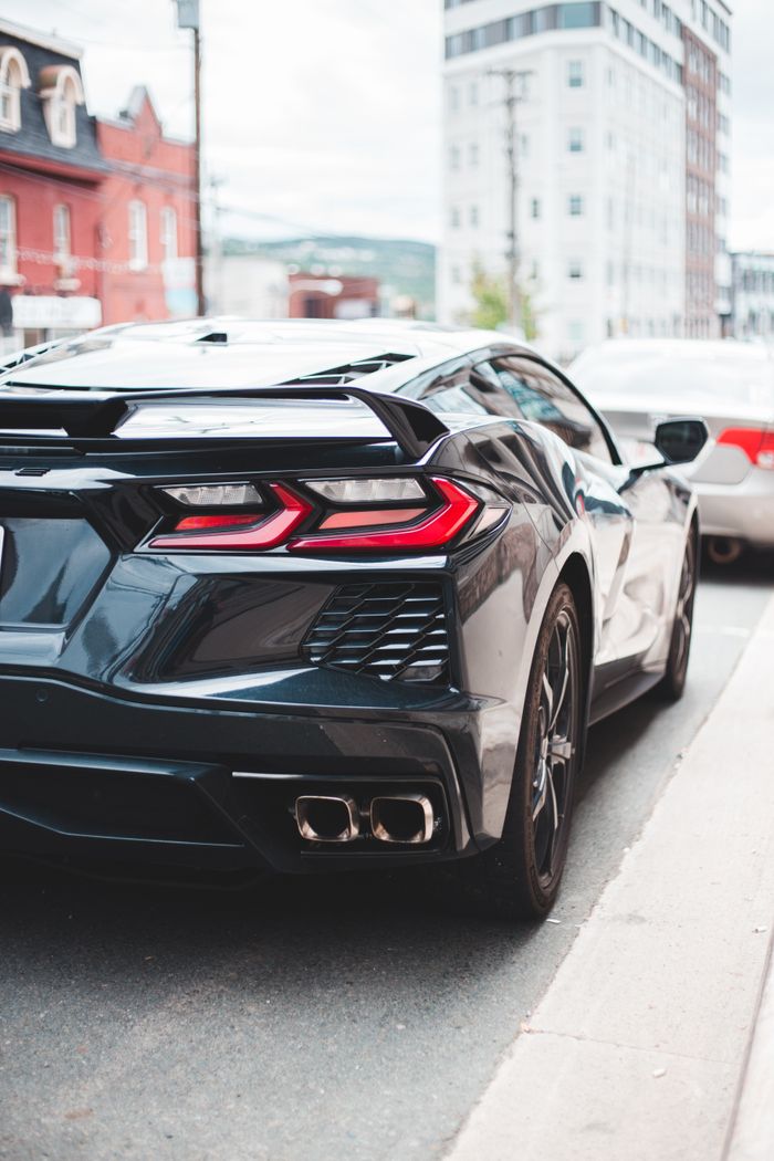 Offerings New shiny auto with elegant spoiler and stylish taillights on street in daylight